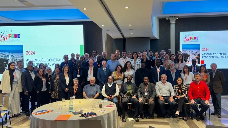 Photographie de groupe d’une assemblée générale, en salle de conférence, réunissant de nombreux participants.