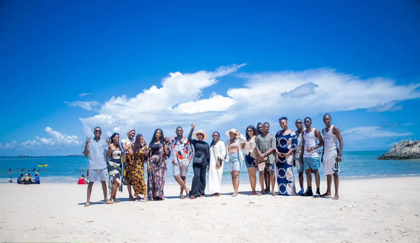 Groupe d’étudiants posant sur une plage de Dakar sous un ciel dégagé, lors d’une journée de détente.