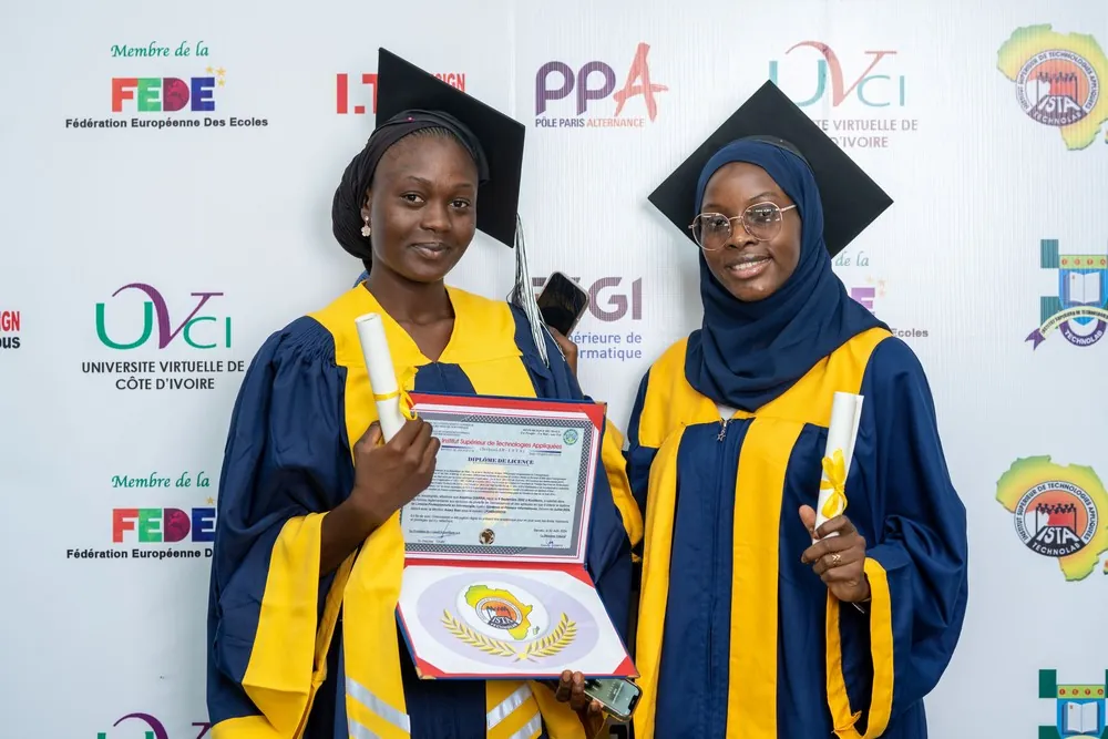 Deux diplômés présentent ensemble leur certificat à l’issue de la cérémonie.